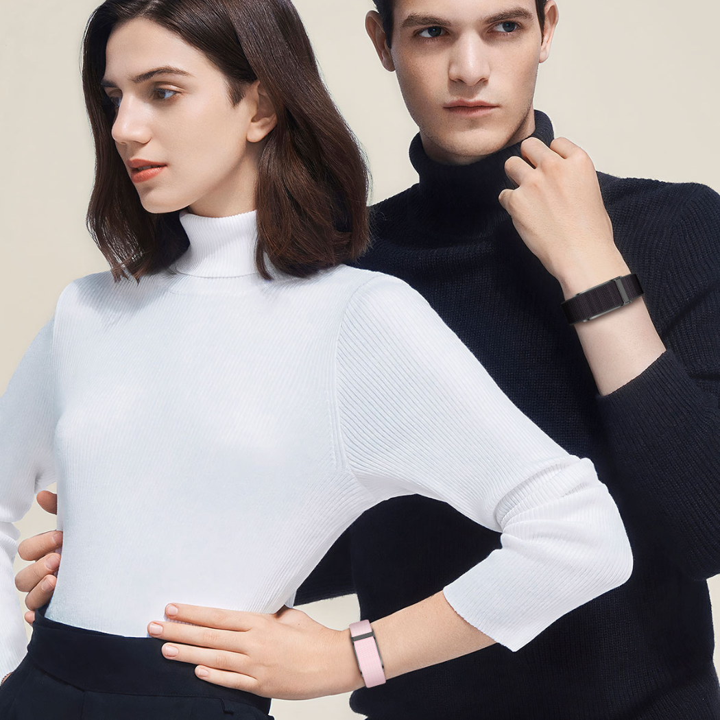 "A fashionable young couple wearing modern smartwatches, showcasing sleek and sporty designs in vibrant orange and classic black."